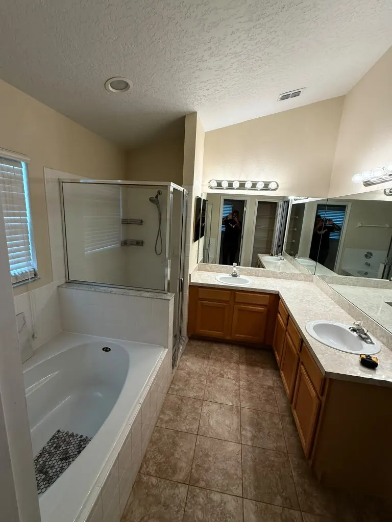 Baño principal anticuado con mueble de roble, cubierta laminada y mampara con marco antes de remodelar